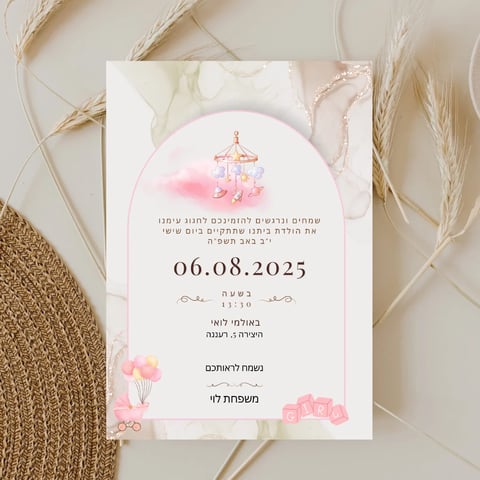 Baby girl birth announcement card with pink carousel design, Hebrew text, and date 06.08.2025, surrounded by dried wheat and burlap on neutral background