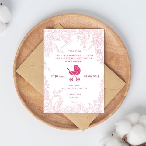 Baby shower invitation card with pink baby carriage design on wooden plate with kraft envelope and cotton decoration